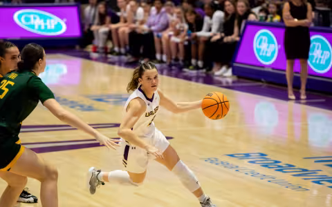 A UAlbany women's basketball player dribbles the ball away from a rival during the UAlbany-Siena game.