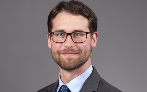 Man in suit and wearing glasses