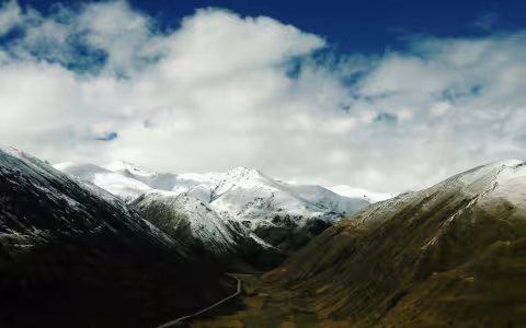 Snow covers the mountain tops on a cloudy day in the Tibet Autonomous Region of China.