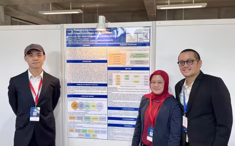 Three people stand in front of a research poster presentation, wearing badges and formal attire.