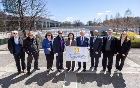 Paul Tonko, UAlbany and community leaders stand in front of the UAlbany greenhouse holding up an ITECA sign.