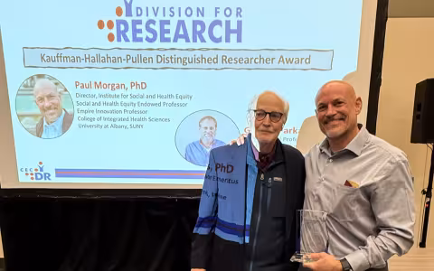 ISHE Director Dr. Paul Morgan holding award