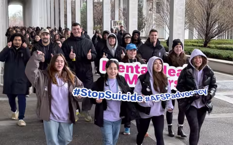 Students marching around UAlbany's podium in support of suicide prevention
