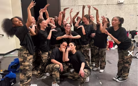 University at Albany Dance Council strike a group dance pose in matching camo and black t-shirt outfits