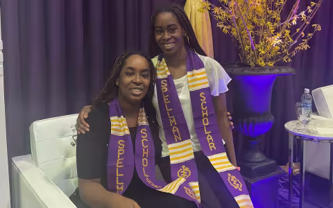 Kehinde and Taiwo Adejumo sit together wearing Seth Spellman Scholar stoles.