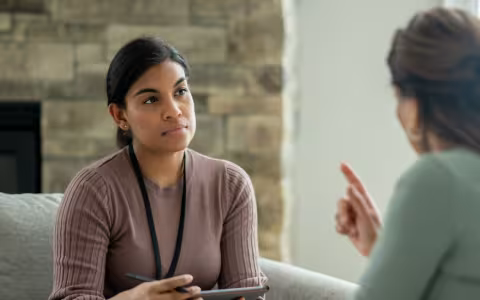 A smiling counselor meets with a client.