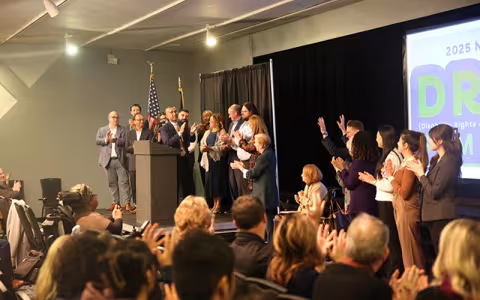 Sanjay Goel on stage at the DREAM Conference, surrounded by other participants in the conference.