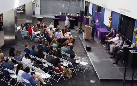 An audience of students, loved ones and professors listening to the dean speak at the awards ceremony. 