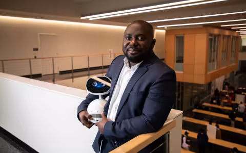 CEHC Benjamin Yankson holds a robot at the new ETEC building.