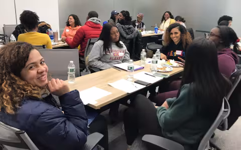 students sitting around tables smiling and talking