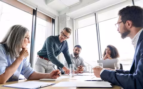 A digital marketing team meets around a conference table.