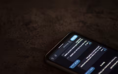 A phone is open on a brown surface with a chatbot conversation on the screen.