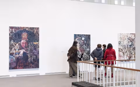 Visitors looking at paintings in the museum