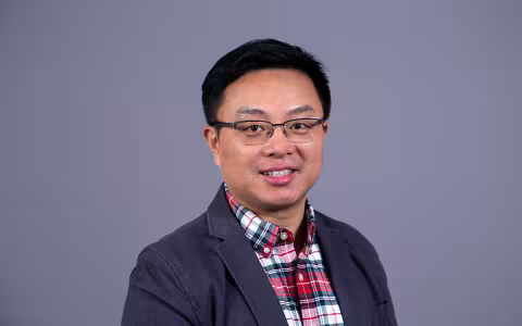 Dr. Qian smiles at the camera.