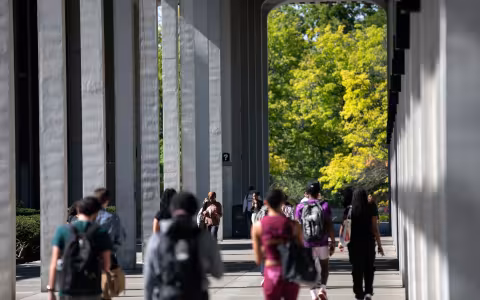 UAlbany Uptown campus with students walking ahead.