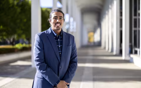 Parmesh Thakoordial stands between the columns on the Academic Podium.