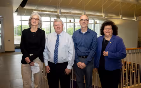 UAlbany faculty Elaine Salisbury, Kevin Knuth and Ryan Torn stand with College of Arts and Sciences Dean Jeanette Altarriba indoors.