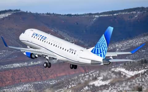 A jet labeled "United Express" flies over mountains.
