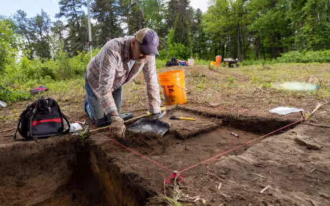Anthropology Professor Christopher Wolff working carefully through the sandy soil at a site in the Albany Pine Bush.