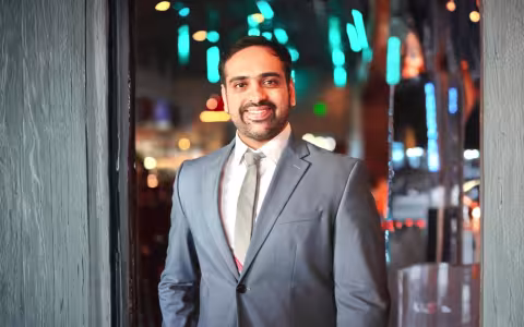 A smiling Rajas Mathkari in a gray suit with a white shirt. 
