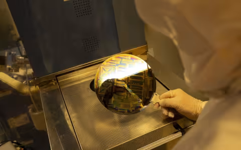 A person in white PPE demonstrates a new state-of-the-art chip design tool.
