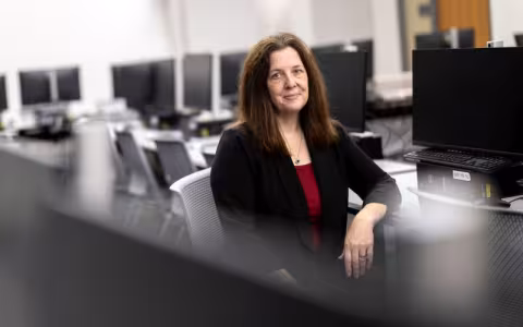 Anne McGrath sits in a computer lab.