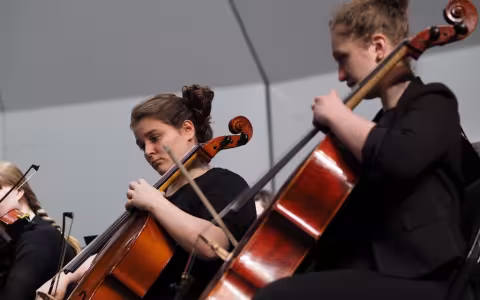 Two people playing instruments on stage.