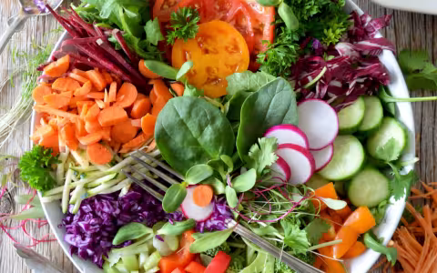 A white bowl filled with healthy salad items.