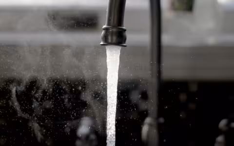 A kitchen faucet with running water.