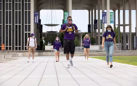 UAlbany students walking on campus wearing masks