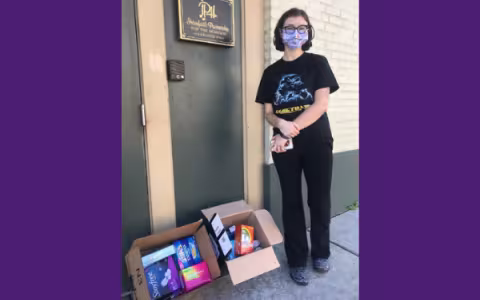 Woman wearing a face mask is smiling at camera.