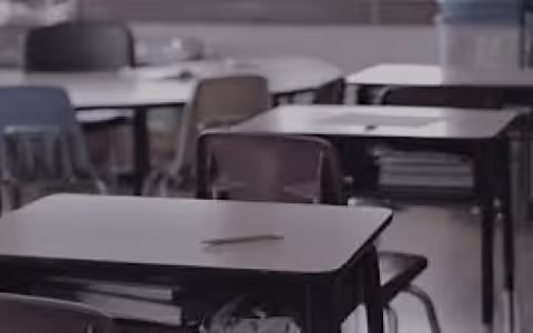 empty school desk with pencil on it