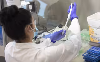 RNA Institute scientist testing a saliva sample for COVID-19