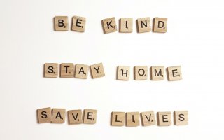 Scrabble pieces spelling out "Be Kind, Stay Home, Save Lives"