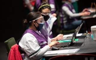 Volunteers working on computers at the POD vaccine site on-campus.