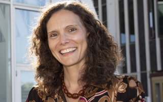 Samantha Friendman, smiling, sits on the Podium