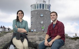 ASRC research associate Sara Lance and DAES student Christopher Lawrence sit in front of the Whiteface Mountain Field Station. 