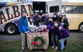 UAlbany students join President Rodriguez to drop off holiday gifts at Northern Rivers.
