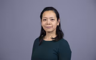 photo portrait shows Tomoko Udo on a blue-gray background
