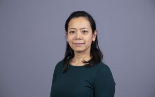 photo portrait shows Tomoko Udo on a blue-gray background