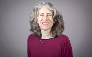 Julie Novkov, smiling in a purple sweater