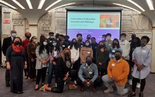 26 students and 2 administrators of color pose in the UAlbany Campus Center