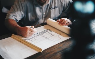 A construction manager looks over blueprint plans
