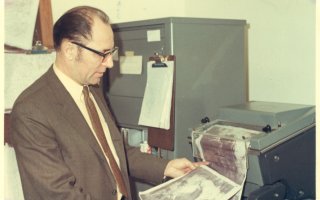 Ray Falconer inspects a weather map on the UAlbany campus.
