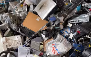 a pile of discarede lams, wires, computer parts and other electric and electronic devises