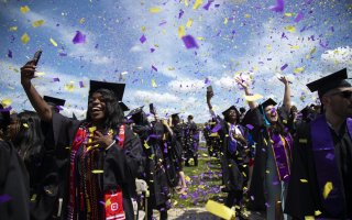 UAlbany graduates celebrate in a sea of purple and gold confetti at the conclusion of the undergraduate ceremony on Saturday, May 14.
