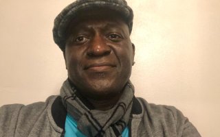 El-Ra Radney wears a hat and scarf and poses for a picture