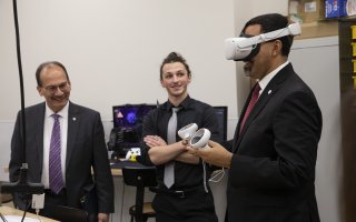 SUNY Chancellor King tries on a virtual reality headset inside ETEC's makerspace.