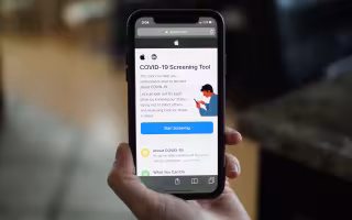 Person holds up phone with COVID-19 Screening Tool app opened.