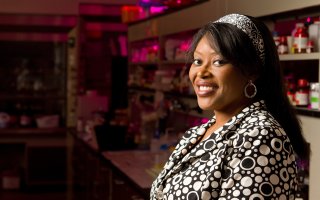 Rabi Musah smiles inside her lab space on campus.
